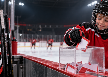 Junger Eishockeyspieler legt einen Vereinsschein in die Sammelbox